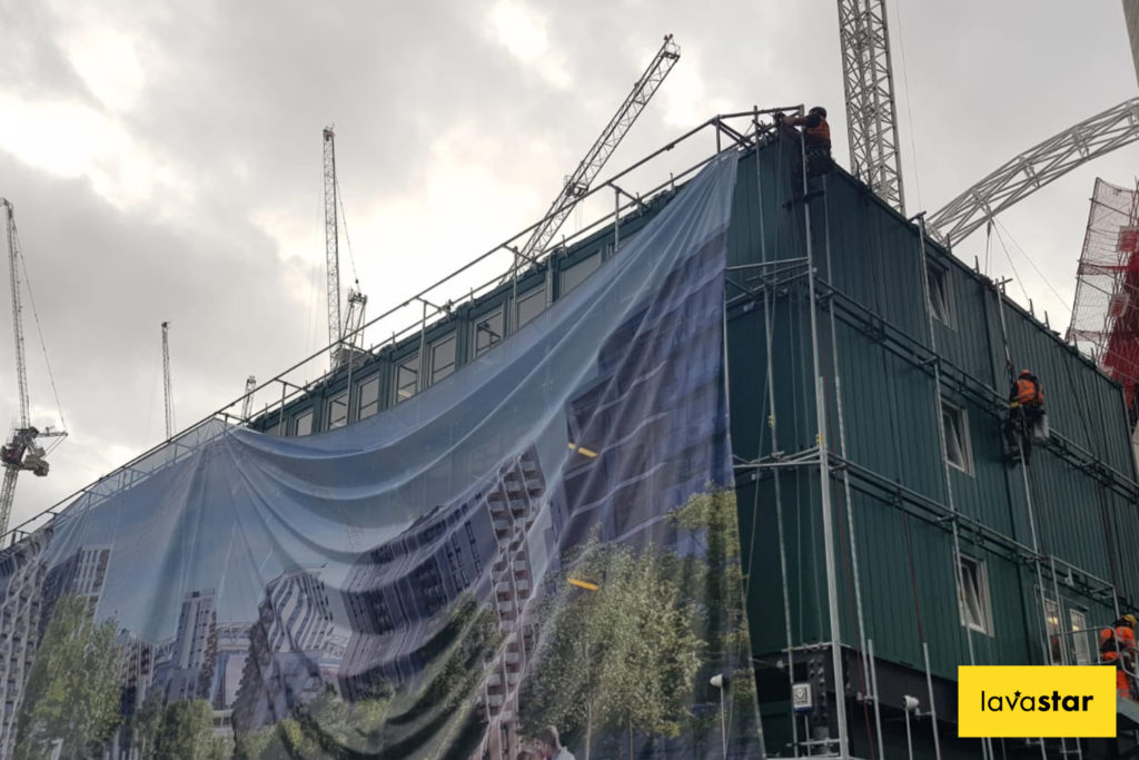 Lifting up a printed banner on a cabin wrap in London