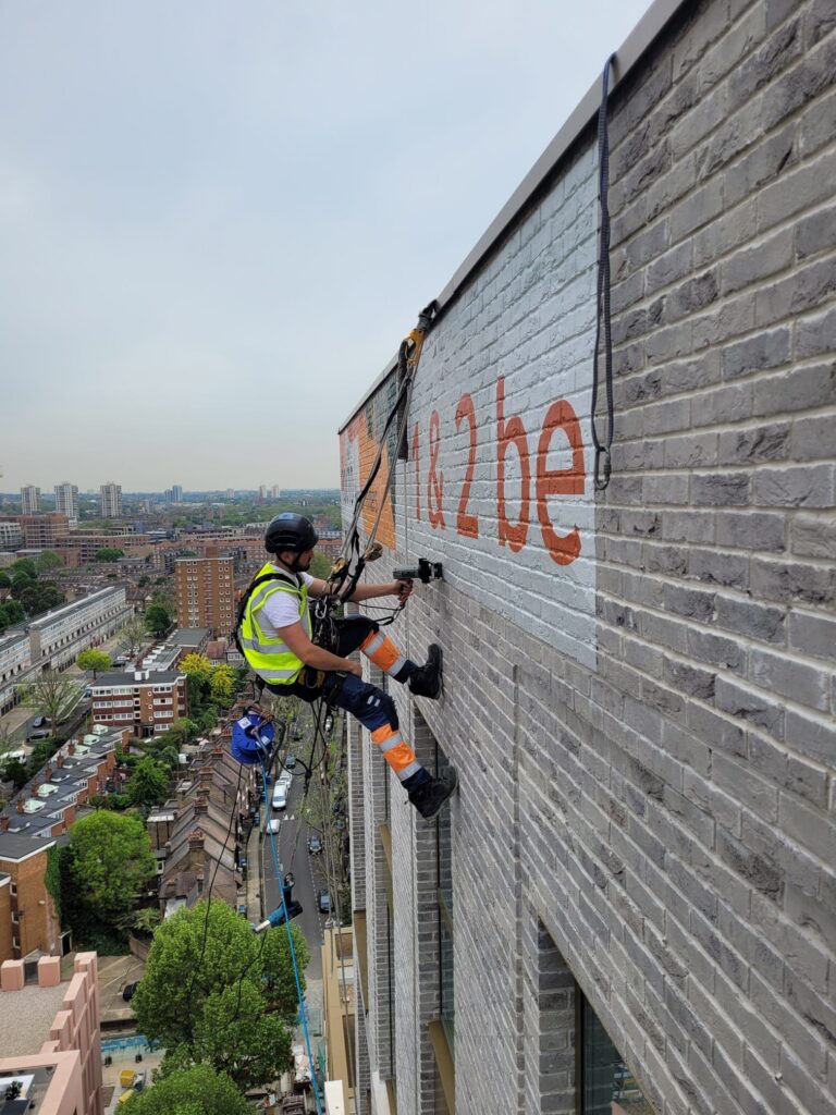 Installing a printed vinyl brickwrap graphic to the exterior of facade in London
