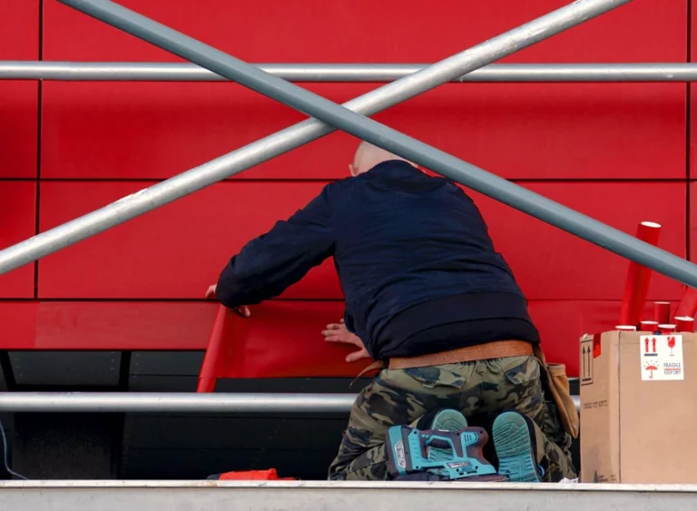Installer applying vinyl to exterior cladded panels